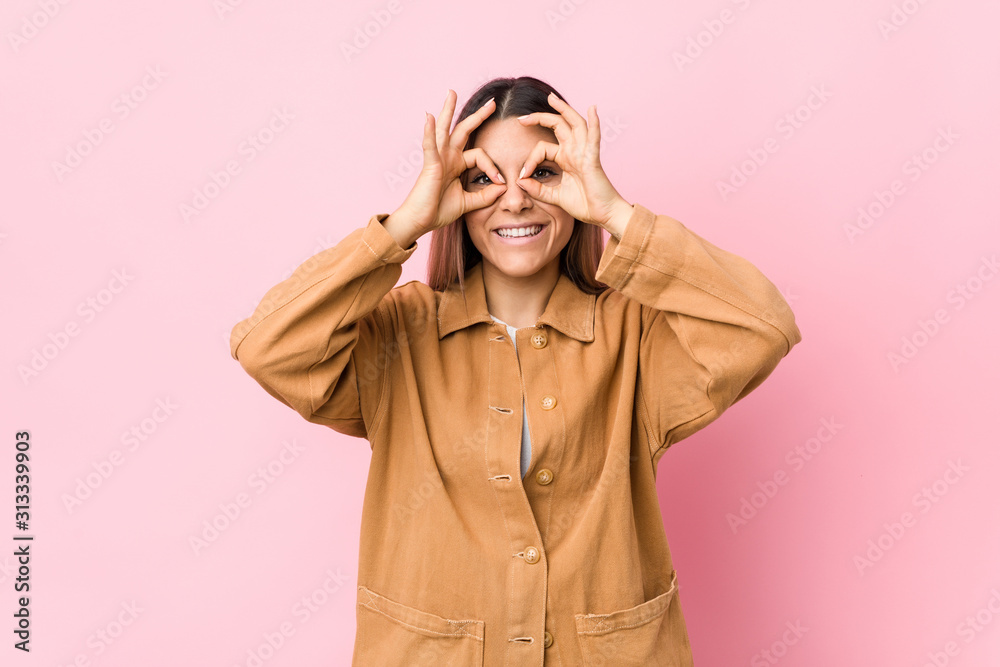 Young caucasian woman isolated showing okay sign over eyes Young caucasian woman isolated showing okay sign over eyes