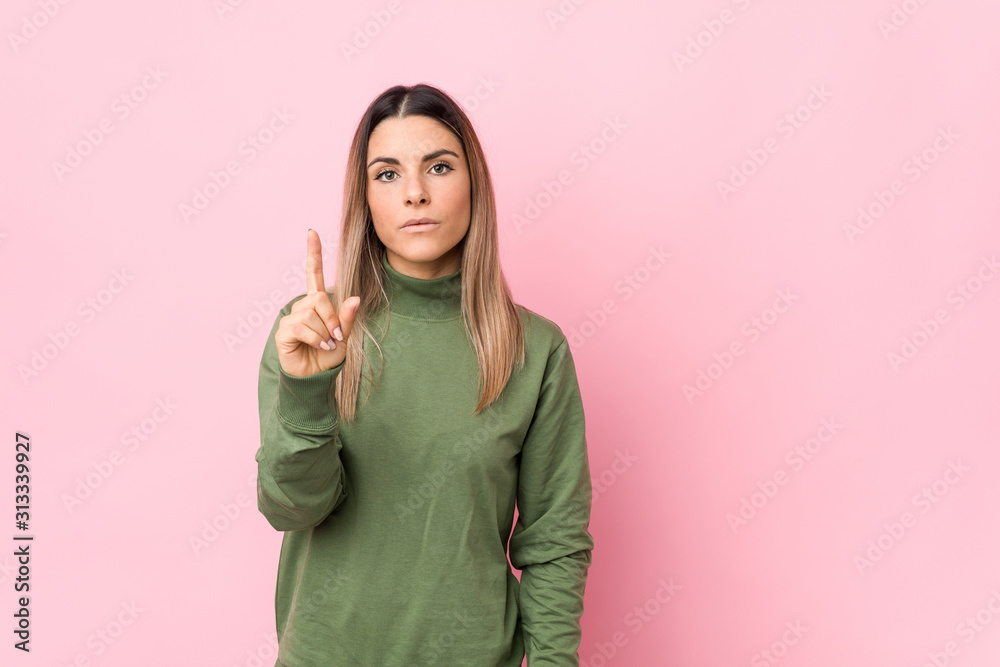 Young caucasian woman isolated showing number one with finger. Young caucasian woman isolated showing number one with finger.