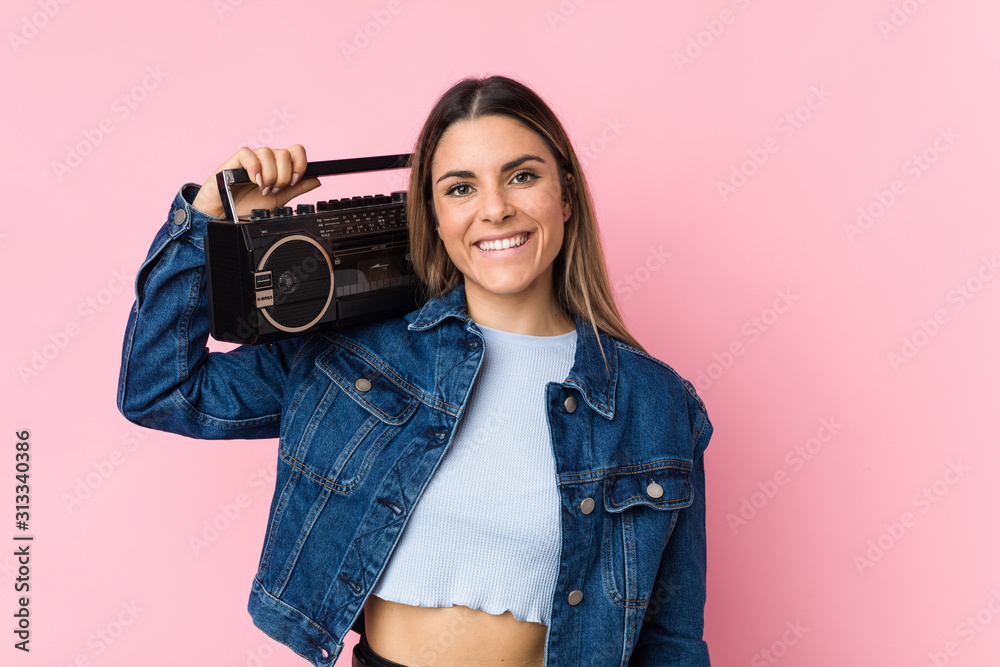 Young caucasian woman holding a guetto blaster happy, smiling and cheerful. Young caucasian woman holding a guetto blaster happy, smiling and cheerful.