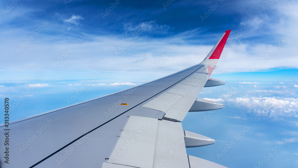 Plane wing on the blue sky and clouds,can be used for air transport to travel and open season to travel background.