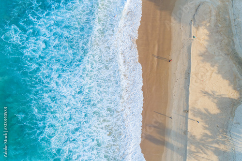 Aerial view sandy beach and waves Beautiful tropical sea in the morning summer season image by Aerial view drone shot, high angle view Top down.