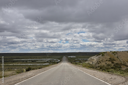 vista de camino en medio de la pradera con nubes sobre el horizonte en patagonia argentina
