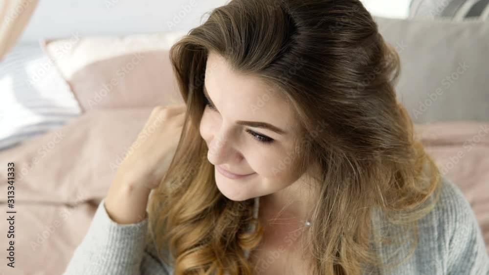 Beautiful lady smiling sitting on bed and adjusting hair, perfect mood, morning Beautiful lady smiling sitting on bed and adjusting hair, perfect mood, morning