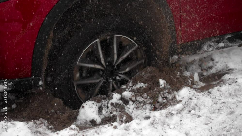 The wheel of car slides on the snow and the ground, can not leave. Red