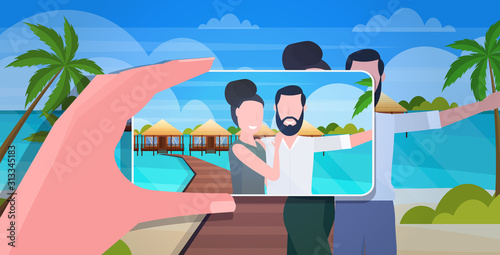 blogger using smartphone camera photographing happy man woman travelers couple on mobile phone blogging shooting vlog concept summer vacation seascape background portrait horizontal vector