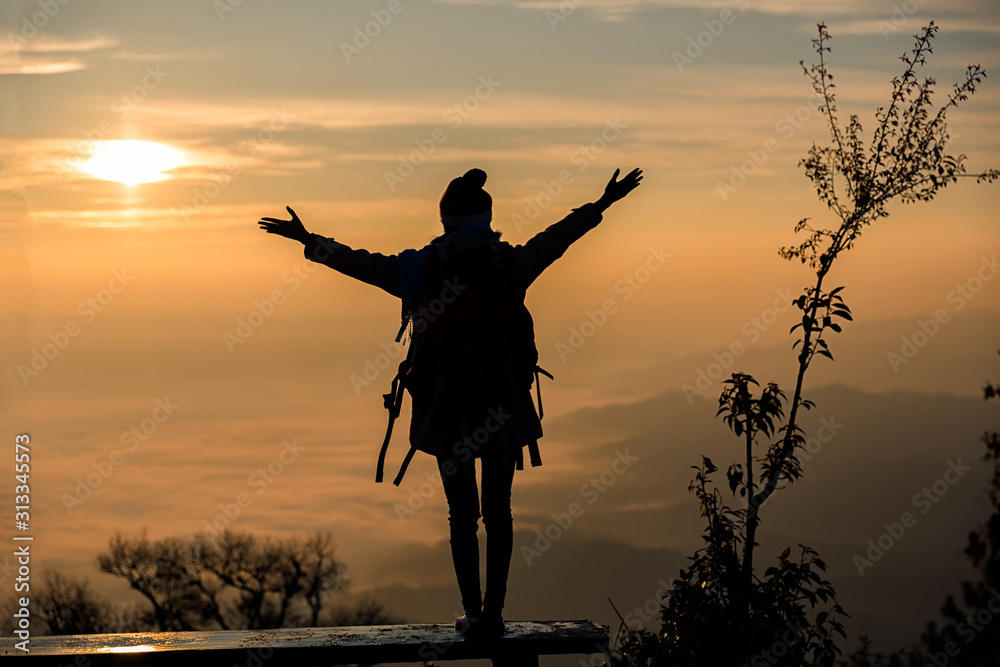 Silhouette Of A Young Girl On A Mountain Top.Young Girl With Backpack Enjoying Sunrise.
