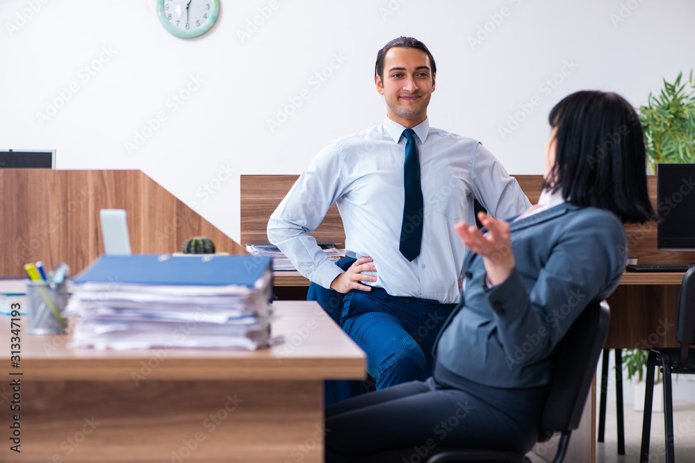 Two employees doing sport exercises in the office Two employees doing sport exercises in the office