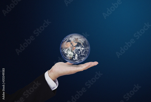 Businessman holding globe  on blue background. Global business concept. Element of this image are furnished by NASA