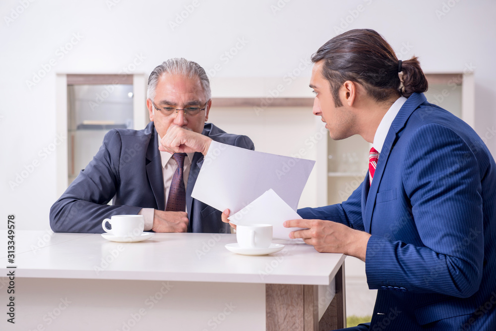 Two businessman discussing business in office Two businessman discussing business in office