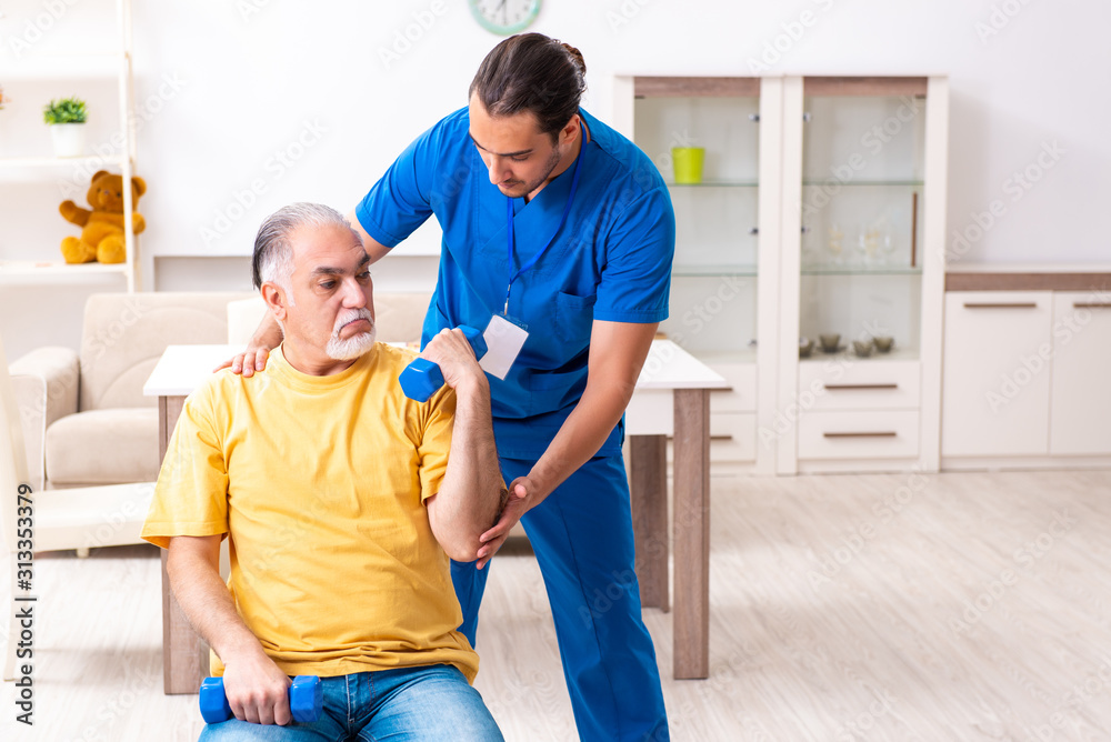 Fototapeta premium Young male doctor visiting old patient at home