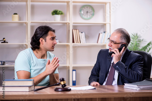 Young man visiting experienced male lawyer