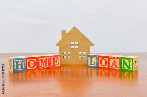 Alphabet wooden block in Home Loan and house toy. Concept of realestate housing sale. Business object on wooden desk. Selective focus.