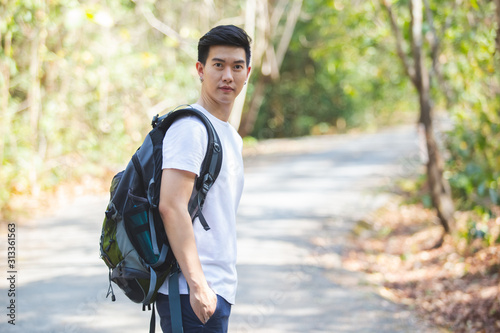 Portrait of asian man with backpack in forest, Travel photography concept.