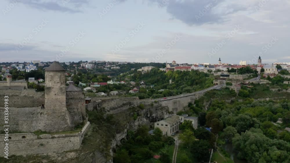 Flying over the castle bridge of the Kamianets-Podilskyi castle to the peaceful city of Ukraine - Aerial shot Flying over the castle bridge of the Kamianets-Podilskyi castle to the peaceful city of Ukraine - Aerial shot