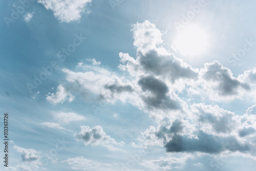 Blue sky with clouds and sun. Beautiful photo of the sun with clouds. The sun behind the clouds.