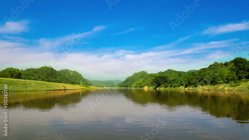 Beautiful Natural Scenery Of River With Blue Sky And Mountain In Background