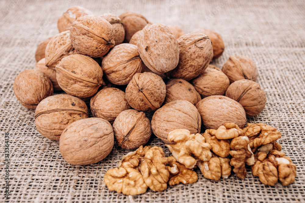 Mature walnuts on woven fabric. Nuts on linen fabric Mature walnuts on woven fabric. Nuts on linen fabric