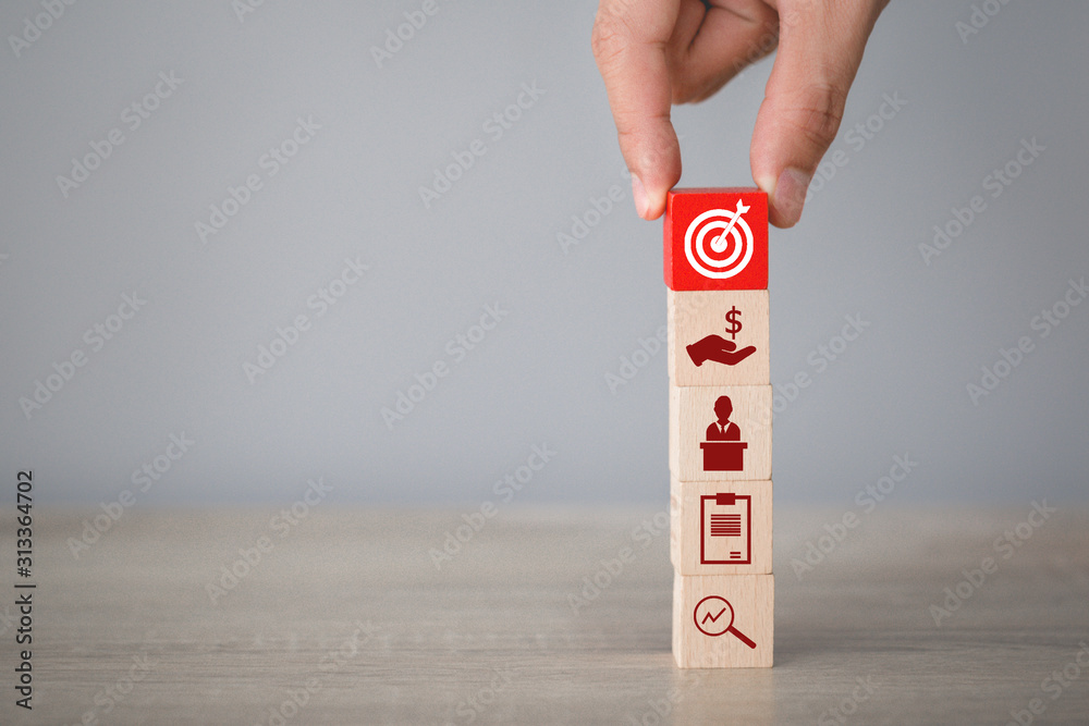 Hand arranging wood block stacking with icon arrow and business,targeting the business concept. Hand arranging wood block stacking with icon arrow and business,targeting the business concept.