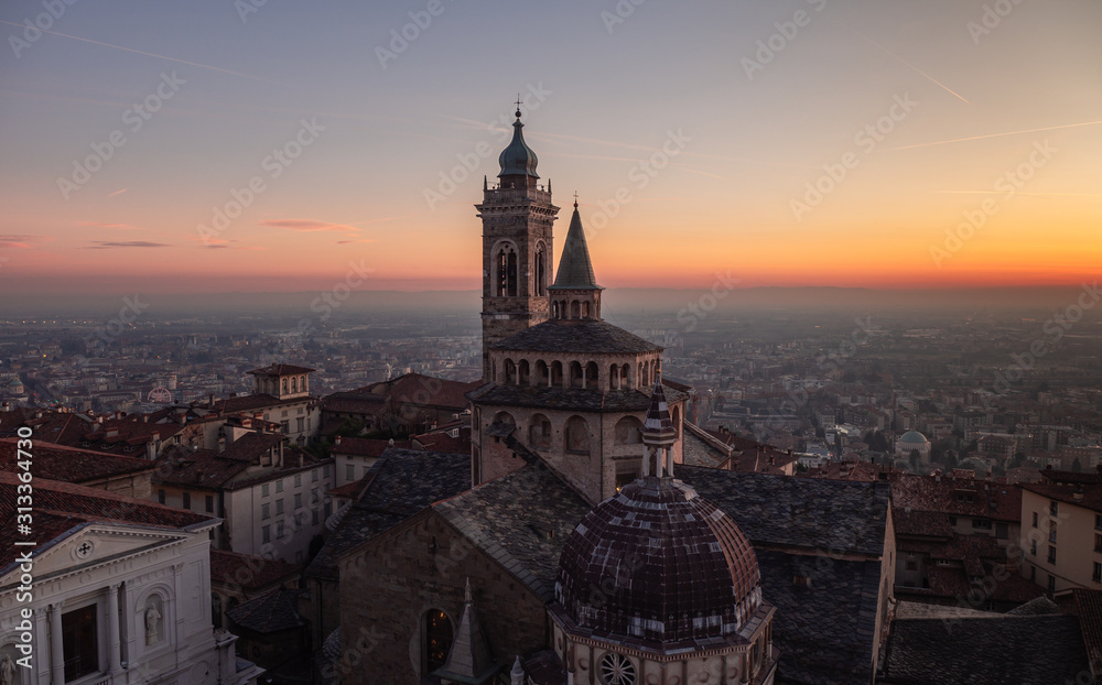 Bergamo, Italy. The old town. Amazing aerial view of the Basilica of Santa Maria Maggiore during a wonderful sunset. In the background the Po plain. Warm colors