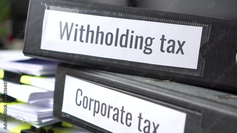Stack of taxes binders report concept: Document of Withholding tax and corporate tax for accountant. withholding tax sometimes applies to royalties, rent or even sale duty must be paid to government Stack of taxes binders report concept: Document of Withholding tax and corporate tax for accountant. withholding tax sometimes applies to royalties, rent or even sale duty must be paid to government