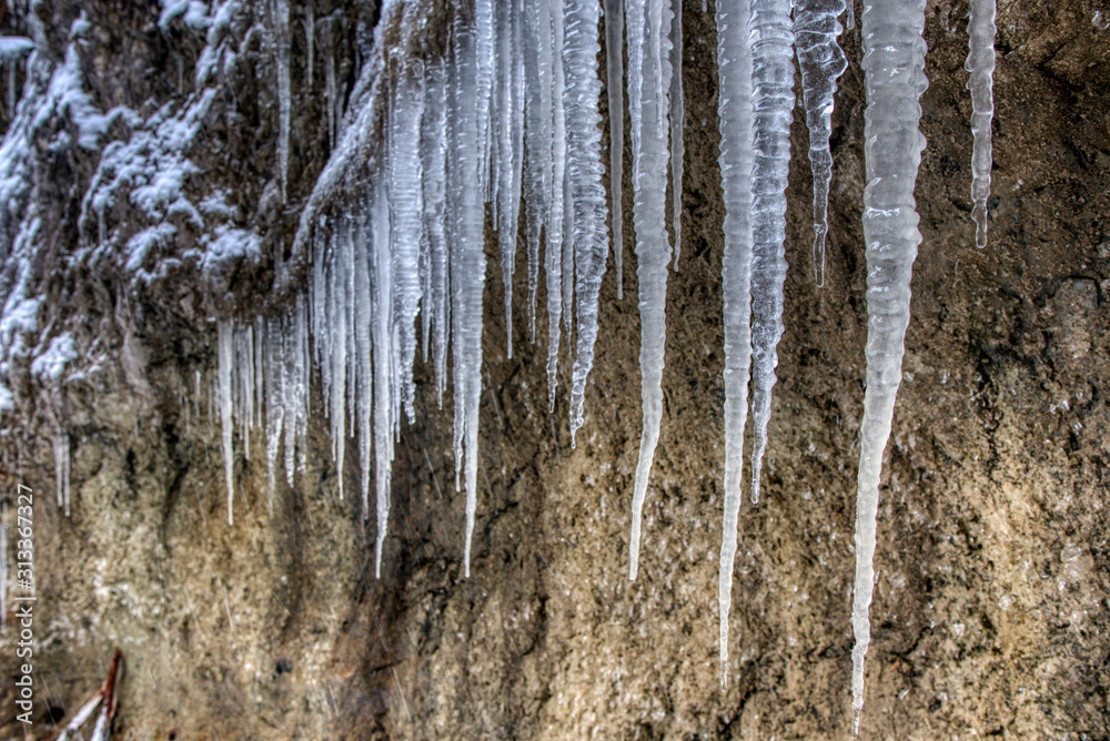 Large stalactites with ice in the mountains on a rock , slovakia mala fatra Large stalactites with ice in the mountains on a rock , slovakia mala fatra