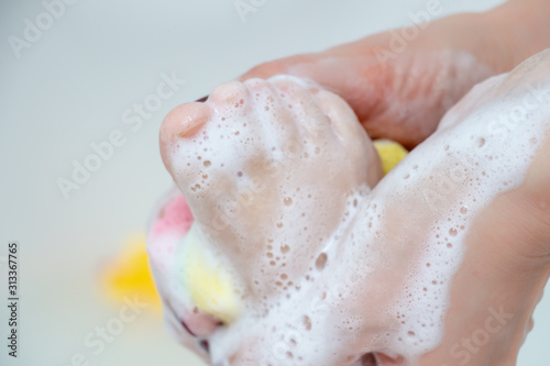 Care and cleanliness concept. Daily washing of the child. A small leg in the hands of the mother, close-up. Bathing for children