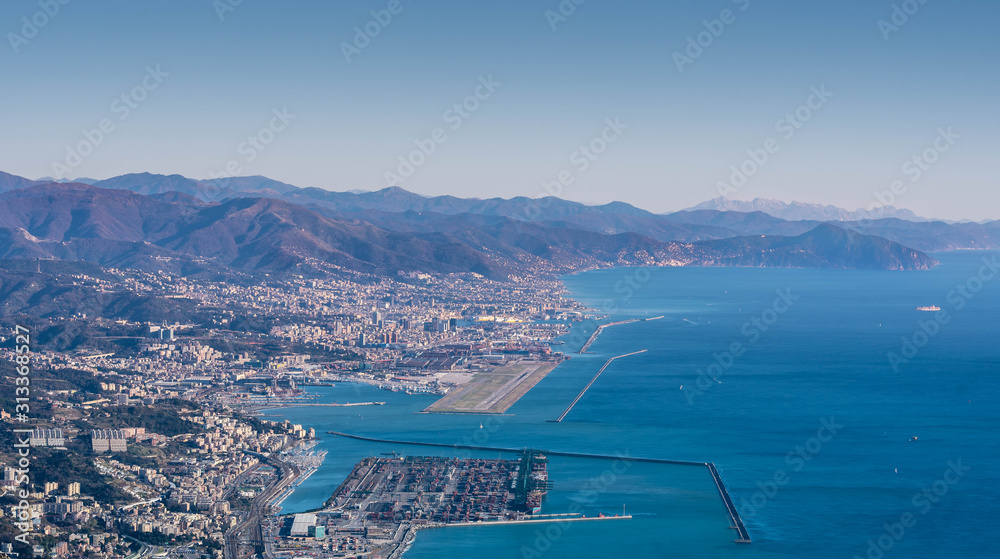 Genoa, Genova, Liguria, Italy: beautiful scenic aerial view of the city, port, dam, sea, Cristoforo Colombo airport runway, and Portofino promontory at sunset