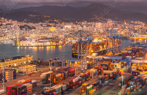 Genova, Genoa, Italy: Aerial view of shipping and container terminal, stacked containers and loading dock side cranes in the port of Genoa, Magazzini del cotone and Porto Antico, sea