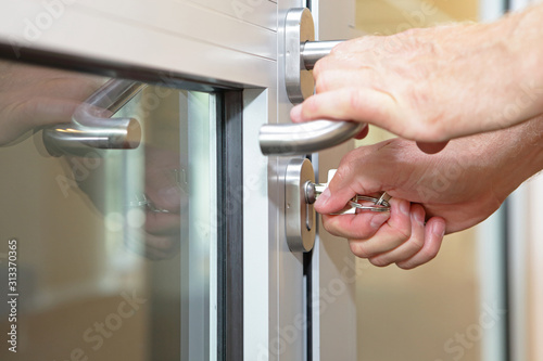Canvas-taulu hands opening locked door  with typical key  - close up