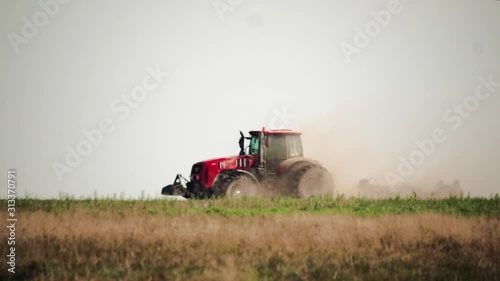 Side view agricultural tractor prepares dusty soil affected by drought. Concept of crop failure with soil erosion and agriculture