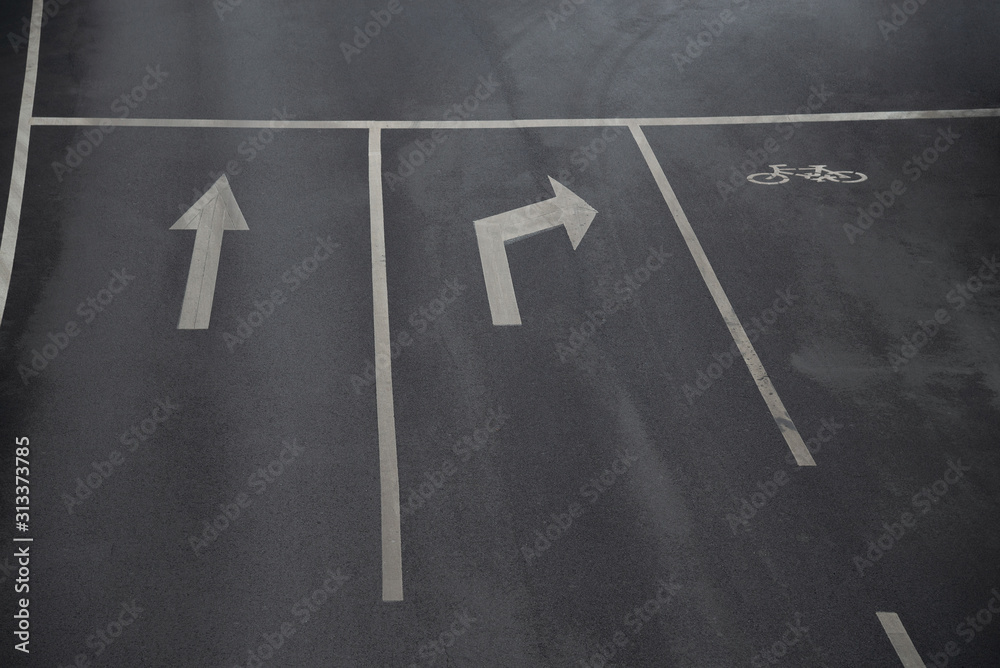 Road sings of straight, right turn arrows and bicycle sign on the asphalt road