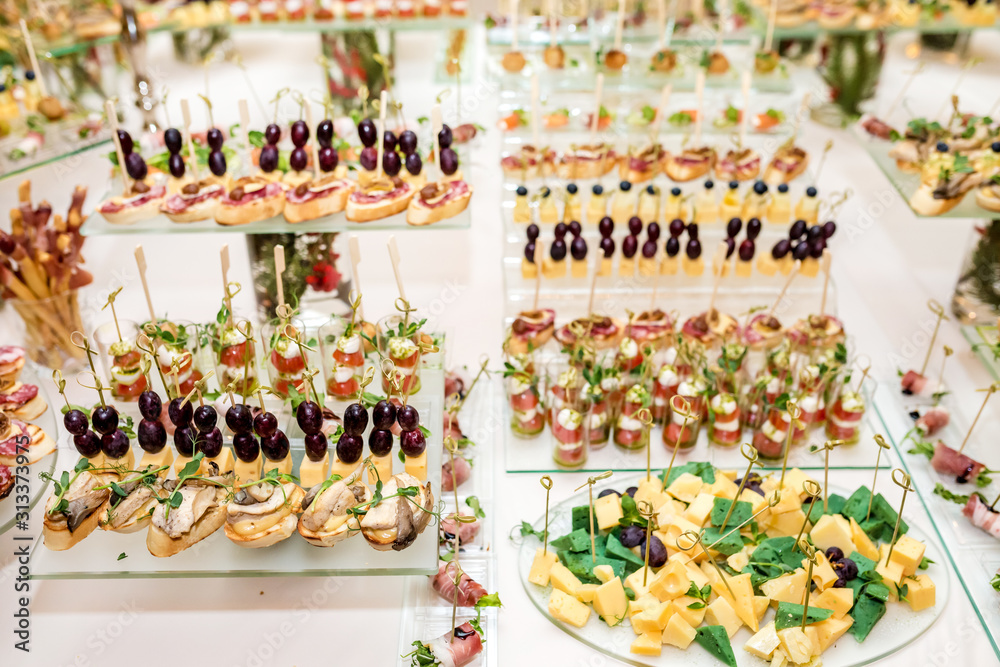 Catering. Off-site food. Buffet table with various canapes, sandwiches, hamburgers and snacks.