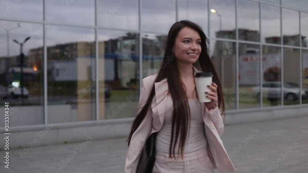 .Beautiful business woman smiling and holds the bag in her hand with coffee .Beautiful business woman smiling and holds the bag in her hand with coffee