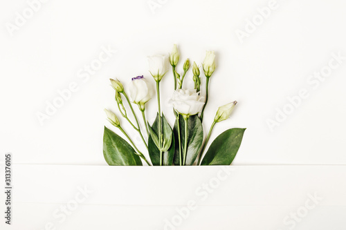 Creative layout made with white flowers on white background. Spring minimal concept, copy space