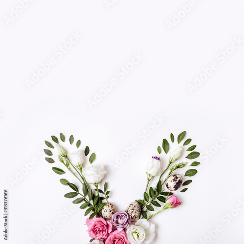 Bunny rabbit ears made of roses flowers  leaves and quail eggs. Happy easter concept  floral boho style