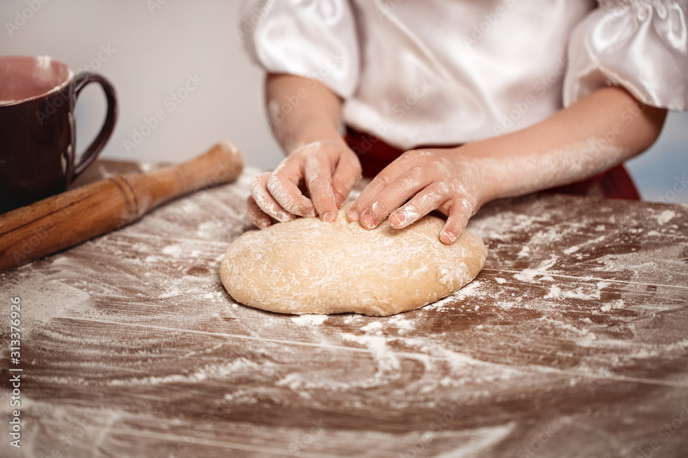 Hands of the child knead dough on a table. Soft focus. Hands of the child knead dough on a table. Soft focus.