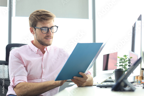 Successful entrepreneur is studying documents with attentive and concentrated look