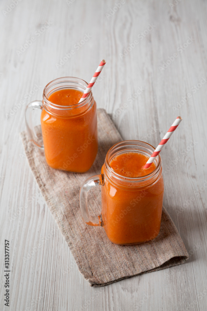 Homemade Mango Carrot Smoothie in glass jars, low angle view. Homemade Mango Carrot Smoothie in glass jars, low angle view.