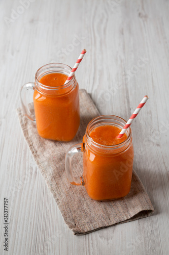 Homemade Mango Carrot Smoothie in glass jars, low angle view.