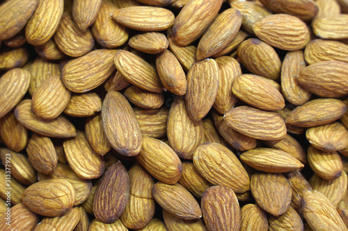 Background of large raw peeled almonds randomly arranged