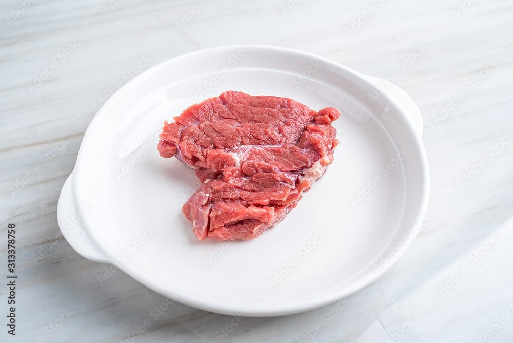 A piece of fresh yellow beef on a kitchen tile countertop plate A piece of fresh yellow beef on a kitchen tile countertop plate
