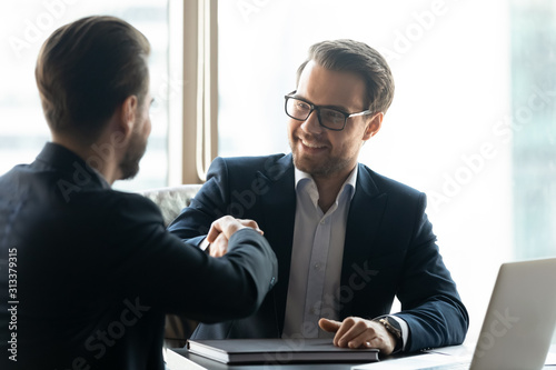 Business partners handshake closing deal at meeting
