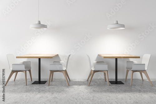 Square dining tables in white cafe interior