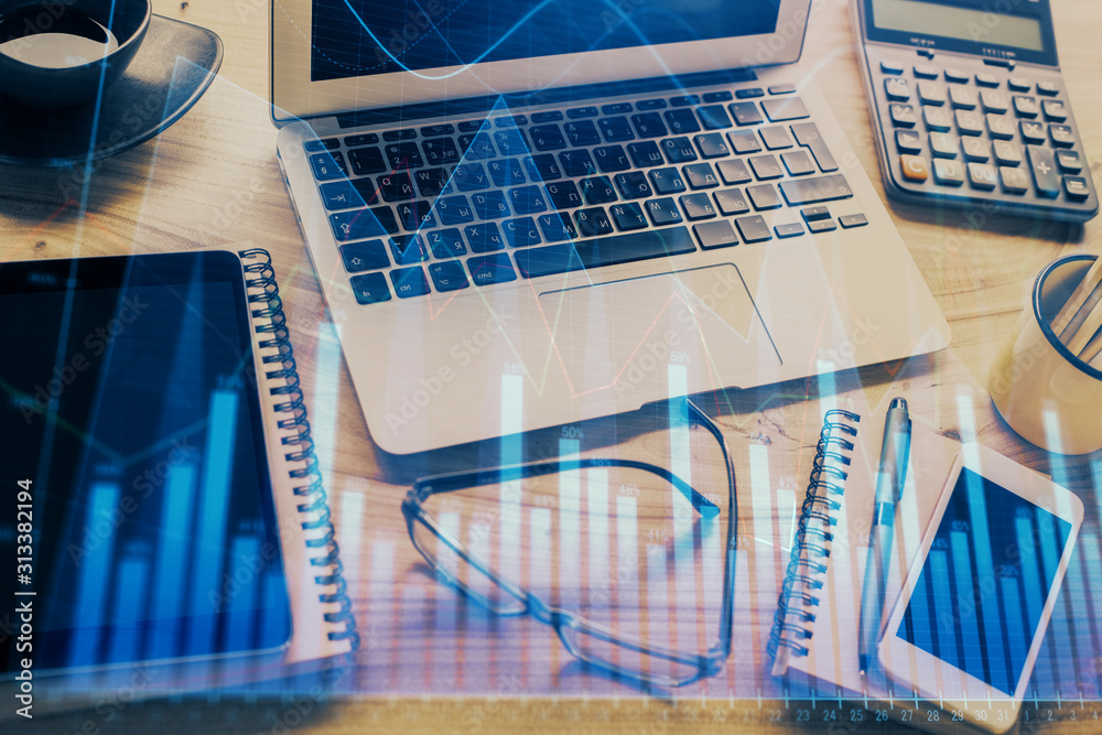 Financial graph colorful drawing and table with computer on background. Double exposure. Concept of international markets. Financial graph colorful drawing and table with computer on background. Double exposure. Concept of international markets.