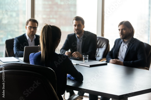 Back view of female applicant talk at work office interview