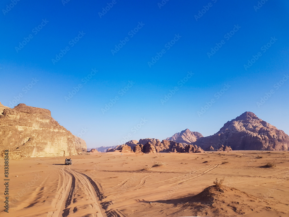 Sunset safari at the Wadi Rum desert, Jordan. Pick up truck tour with bedouins. Car rides on the sand in the middle of two rocky mountains at the famous desert. 