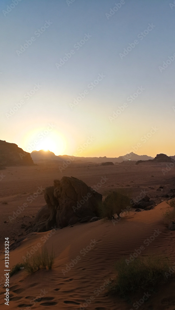 Sunset in Wadi Rum desert. Sundown and rocky mountains. Safari ride on pick up trucks. Surface of Mars.