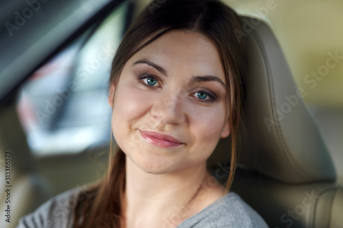 Portrait of real young attractive caucasian woman behind the wheel driving a car. Happy smile, positive emotions. Copy space. © Elena
