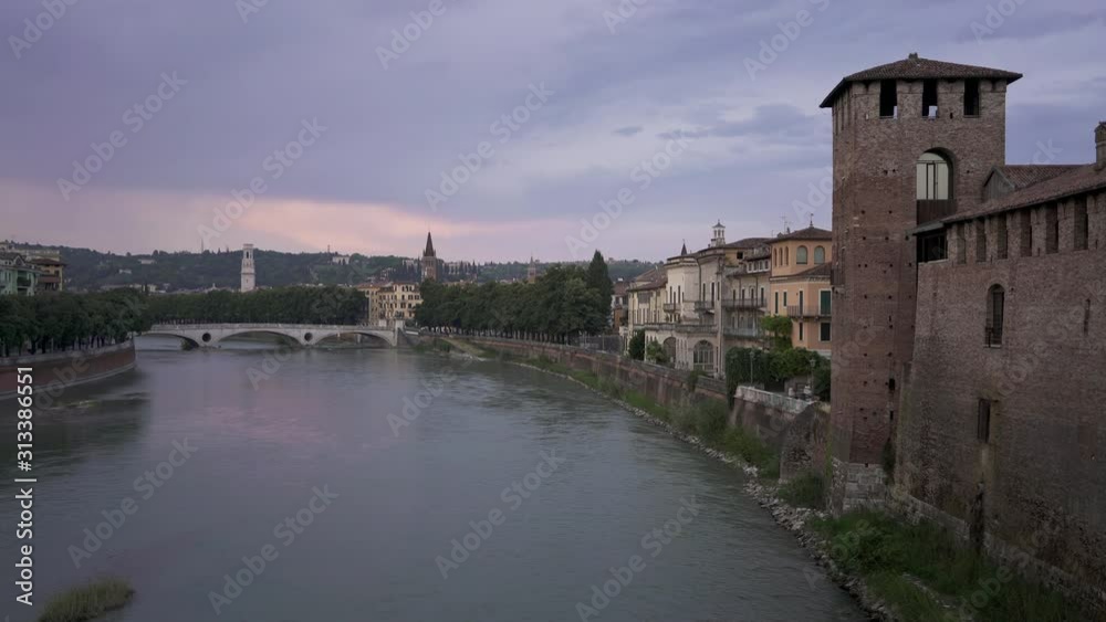 View of Bridge of the Victory in old city of Verona under cloudy grey sky in summer. Gimbal shot of view on Verona and the bridge View of Bridge of the Victory in old city of Verona under cloudy grey sky in summer. Gimbal shot of view on Verona and the bridge