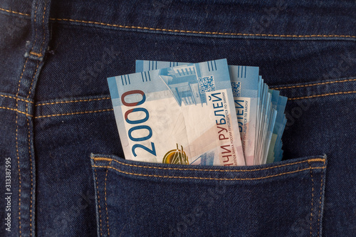 Bunch of 2000 rouble banknotes in the back pocket of a blue jeans.